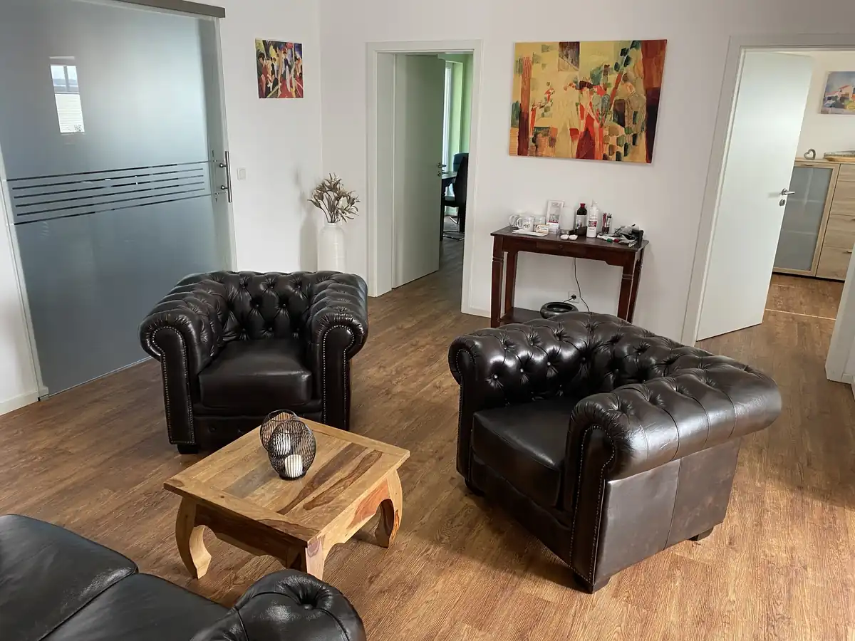 Gesprächsraum mit zwei Chesterfield-Sesseln und einem Holztisch