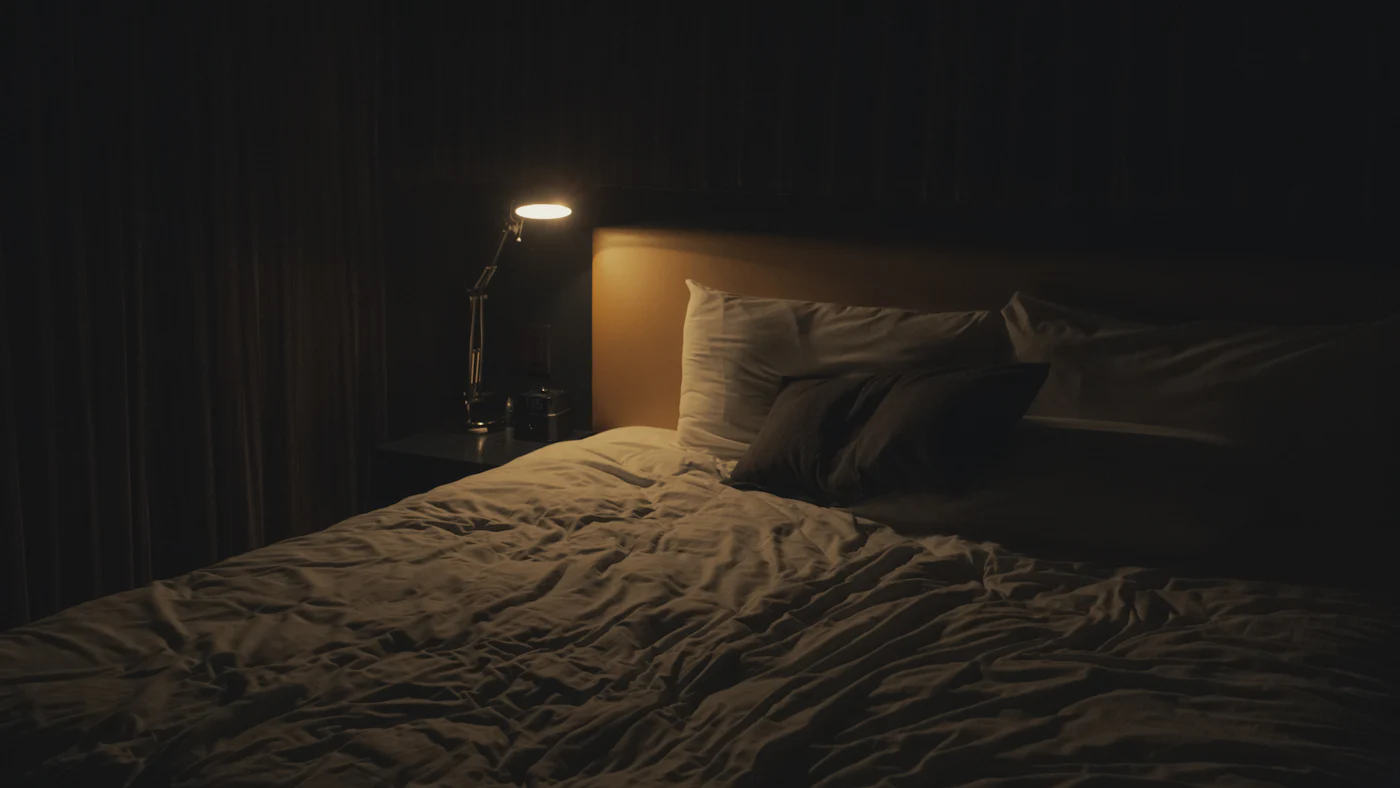 Ein nächtliches Schlafzimmer, nur eine Nachttischlampe brennt
